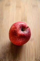 One single red apple on wooden cutting board in the kitchen, healthy diet Vitamin C fruit