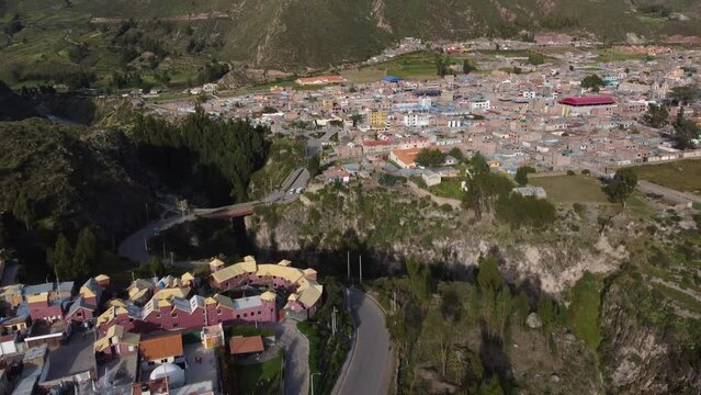 Colca Canyon, Peru: Aerial drone footage of the Chivay town with the Inca bridge above the Colca river in famous Canyon in the Andes mountains in Peru in south America. Shot with a tilt up motion