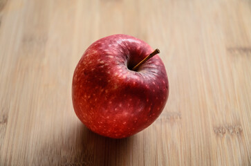 One single red apple on wooden cutting board in the kitchen, healthy diet Vitamin C fruit
