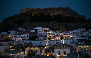 Evening view of the ancient Acropolis of Lindos and snow white houses.