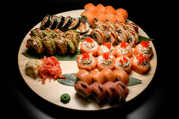 Set of sushi rolls with tuna, salmon, red caviar, avocado, some with sauce and sesame