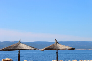 Wicker parasol on the beautiful beach in Brela, Croatia.