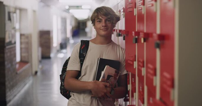 School, locker and kid with books for learning, education or studying in hallway corridor. Portrait, teenager and student with face of young boy for knowledge development, scholarship or confident
