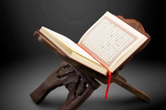Open Holy Quran book on wooden table
