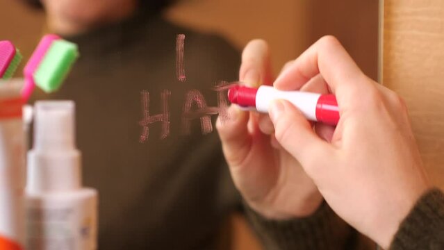 The girl writes with red lipstick a confession of hatred i hate you