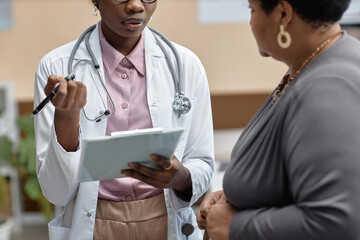 Cropped shot of Black woman general practitioner wearing lab coat with stethoscope questioning...