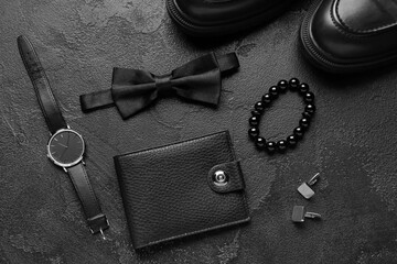 Set of stylish male accessories with bow tie on dark background