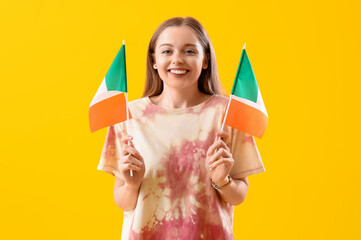 Pretty young woman with flags of Italy on yellow background