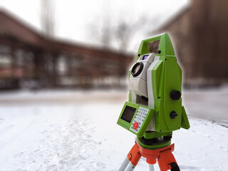 Total station at work on a blurred industrial background. Electronic total station - modern geodetic instrument combines engineering tacheometer and a 3D laser scanner.