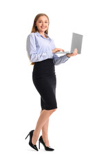 Pretty young businesswoman with laptop walking forward on white background