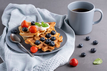 Delicious waffles with whipped cream, strawberries and blueberries