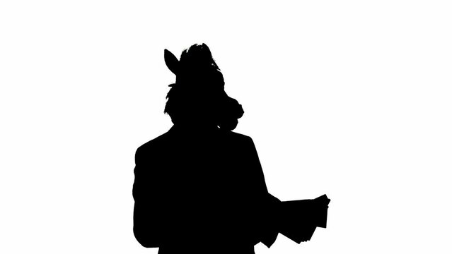 Black silhouette of man in business suit with horse head mask on white isolated studio background. A businessman is looking through documants and dancing merrily. Concept of hard office work.