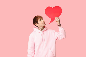 Handsome young man with speech bubble on pink background. Valentine's Day celebration