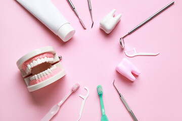 Frame made from dental tools, oral hygiene supplies and plastic models on pink background. World Dentist Day - obrazy, fototapety, plakaty