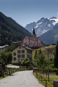 View of Trient village and pink church in Martigny, Valais in Switzerland. With beautiful mountains in the background. It is a popular tourist destination in the Swiss Alps.