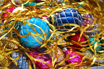 Christmas balls, foil cones and decorations with gold tinsel close-up. Beautiful bright decorative...