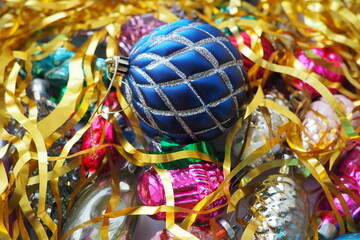 Christmas balls, foil cones and decorations with gold tinsel close-up. Beautiful bright decorative...