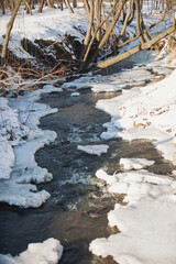A forest in the snow in the winter. frozen water fall with snow. river in winter in lapland, finland. Winter riverside landscape covered with snow