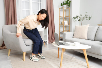 Young Asian woman with hemorrhoids at home