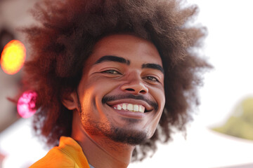 A man with an afro and a beard is smiling