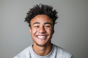 A young man with curly hair is smiling for the camera