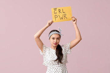 Beautiful young Asian pin-up woman holding card with text GIRL POWER on pink background