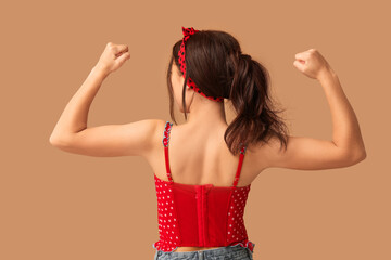 Pin-up woman showing her muscles on brown background, back view