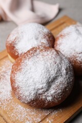 Delicious sweet buns with powdered sugar on table, closeup
