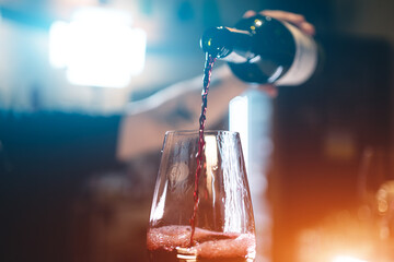 bartender pouring red luxury wine in wineglass, closeup macro