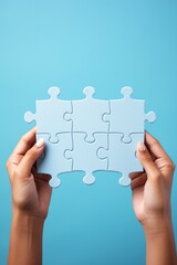 Light blue puzzle pieces in Caucasian female hands on blue background