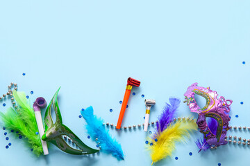Carnival masks with feathers and party horns for Mardi Gras celebration on blue background