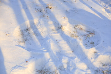 Fototapeta na wymiar Footprints of a snow angel in the park. Background with selective focus and copy space