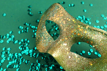 Shiny carnival mask with sequins for Mardi Gras celebration on green background