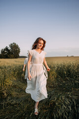A woman wearing a white dress standing in a field of tall grass 5697.