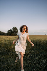 A young woman wearing a white dress running through a field 5701.