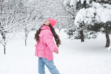 Fototapeta na wymiar Cute teenage girl 14-15 year old having fun in snow outdoor. Winter holiday season.