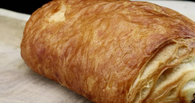 So sweet and delicious - roll made from puff pastry and brilliant chocolate filling on a rotating plate