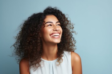 Happy african american woman with curly hair on blue background.