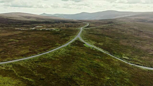 Two roads merging into one, mountain landscape in Ireland, aerial view