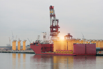 Process Of Loading Wind Generators Foundations Monopiles On A Semi-Submersible Installation Heavy Lift Vessel For The Offshore Wind Industry © I am from Mykolayiv