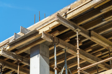 An outdoor construction site. Construction of a new building. Block construction, reinforced concrete beams and wooden floors and roofs.