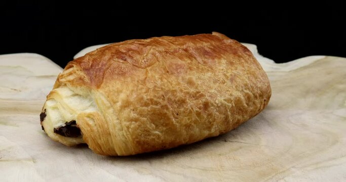 A single choco croissant close-up. Video on a rotating disk