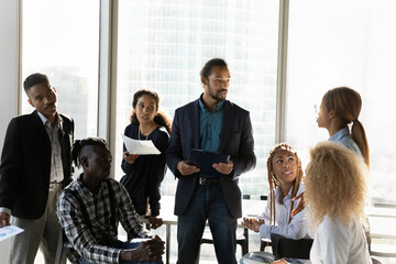 Diversity of opinions. Skilled millennial boss discuss business project with mixed race working...