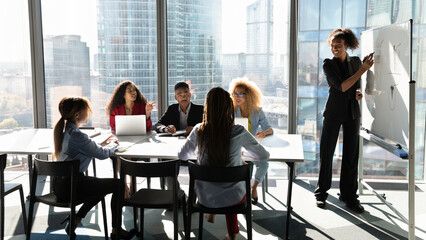 Business education. Diverse group of young mixed race employees gathered in boardroom on training...