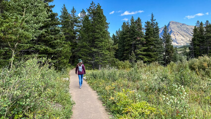 Woman Hiking around Swiftcurrent Lake in Many Glacier Region of Glacier National Park