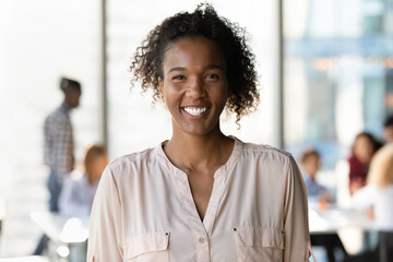 Modern youth representative. Headshot portrait of happy smiling millennial mixed race woman employee student posing in office university. Casual young black female teenager look at camera in good mood