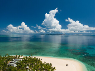 High angle view of tropical island and beach in Fiji with water, sky and clouds