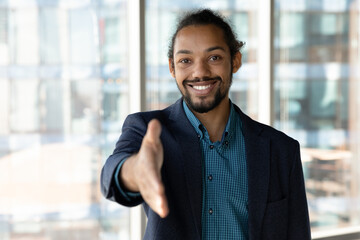 Obraz premium Portrait of happy young black hr manager look at camera stretch hand to you meeting new staff member hired after job interview. Friendly biracial man agent introduce himself to client business partner