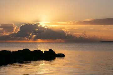 Tranquil seascape view with dramatic sky and sun rays breaking through the clouds.