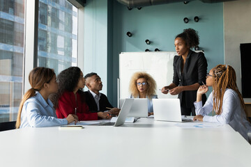 Young diverse multiethnic business team gather on briefing in modern office under lead of afro...